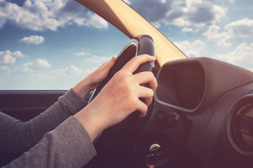 Woman hands on steering wheel of a car