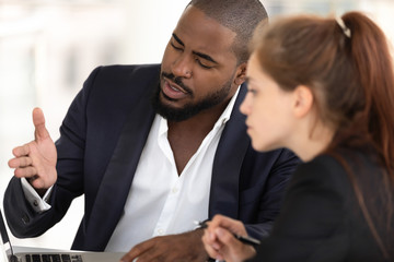 African american businessman mentor teaching caucasian intern with computer