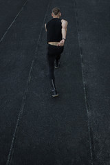 caucasian man doing a sprint start. running on the stadium on a track. Track and field runner in sport uniform. energetic physical activities. outdoor exercise, healthy lifestyle. vertical top view