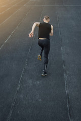 caucasian man doing a sprint start. running on the stadium on a track. Track and field runner in sport uniform. energetic physical activities. outdoor exercise, healthy lifestyle. vertical top view
