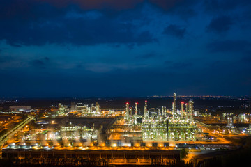 Aerial view. Oil refinery factory and oil storage tank at twilight and night. Petrochemical Industrial.