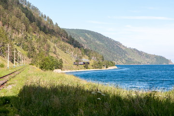 Fototapeta na wymiar Green landscape with mountains, blue lake, forest, railway tracks and steam train