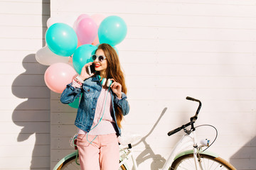Cheerful smiling girl came by bicycle to congratulate her friend on her birthday and present a...