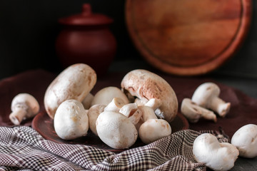 Fresh champignon mushrooms group on the table. Fresh vegetables mushrooms - the concept of healthy proper nutrition. Dark Food Photography