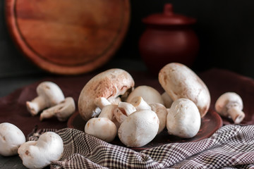 Fresh champignon mushrooms group on the table. Fresh vegetables mushrooms - the concept of healthy proper nutrition. Dark Food Photography