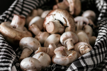 Fresh champignon mushrooms group on the table. Fresh vegetables mushrooms - the concept of healthy proper nutrition. Dark Food Photography