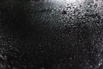 Drops of water on the black glass. Side view