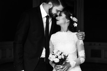 stylish luxury bride and handsome elegant groom hugging on the background of rich interior in old...
