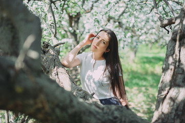 Beautiful girl posing in the blooming garden. apple, cherry