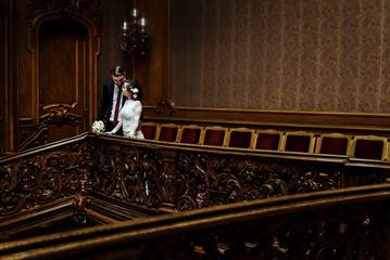 stylish luxury bride and handsome elegant groom standing on the background of old wooden  luxury interior