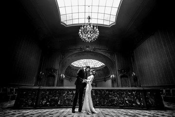 stylish luxury bride and handsome elegant groom dancing on the background of old wooden  luxury interior