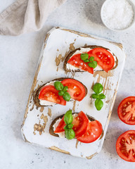 Toasted bread with tomatoes, ricotta (cream cheese), basil