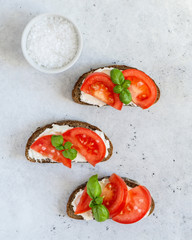 Toasted bread with tomatoes, ricotta (cream cheese), basil