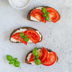 Toasted bread with tomatoes, ricotta (cream cheese), basil