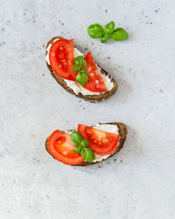 Toasted bread with tomatoes, ricotta (cream cheese), basil