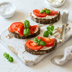 Toasted bread with tomatoes, ricotta (cream cheese), basil