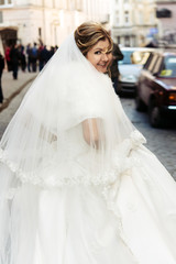 happy luxury bride running  and stylish groom having fun emotions on the background old sunny city