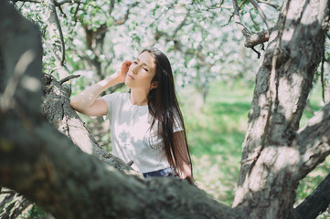 Beautiful girl posing in the blooming garden. apple, cherry
