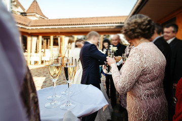 waiter holding tray  with glasses of champagne for happy people toasting and cheering, celebrating...