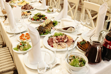 stylish fashionable decorated table with flowers and delicious food, celebration wedding, catering in the restaurant