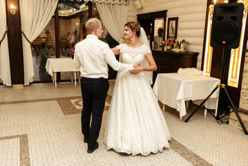 Fototapeta premium happy gorgeous bride and stylish groom dancing in rich restaurant with tender feelings, romantic moment