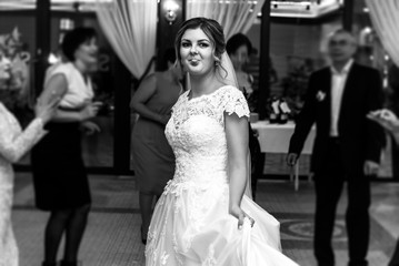 Fototapeta premium happy gorgeous bride and stylish groom dancing and having fun at luxury wedding reception