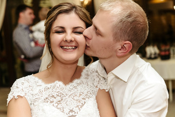 happy gorgeous bride and stylish groom dancing and having fun at luxury wedding reception