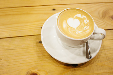 beautiful stylish stunning white cup with latte and a heart on a wooden table