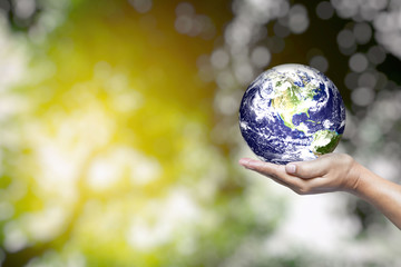 World in Hand and Blurred Beautiful Bokeh in the Garden Background with Space for Text, Suitable for Business and Environment Concept. Elements of this Image Furnished by Nasa.