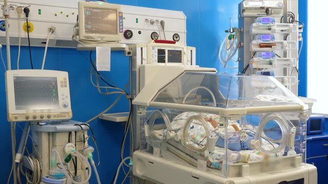 Equipped medical room with a toddler lying in the incubator