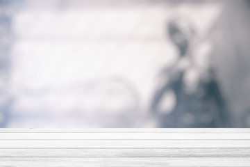 White Wood Table with Blurred Statue in the Garden Background, Suitable for Product Display and Business Concept.