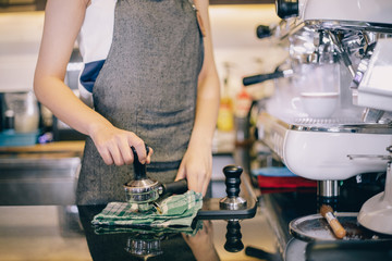 Asian women Barista smiling and using coffee machine in coffee shop counter - Working woman small business owner food and drink cafe concept
