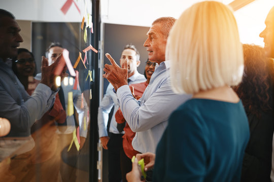 Mature manager brainstorming with his team in a modern office