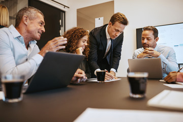Diverse business colleagues talking together in an office boardr