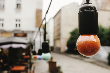 retro beautiful lamp lights on garland at cafe terrace in the street in europe city holiday, space for text