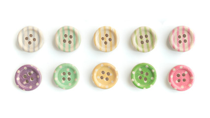 Obraz premium Wooden buttons with colorful stripes and colorful dots on a white background