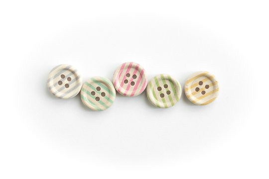 Wooden buttons with colorful stripes and colorful dots on a white background