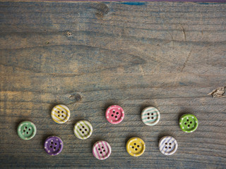 Fototapeta na wymiar Wooden buttons with colorful stripes and colorful dots on a wooden background.