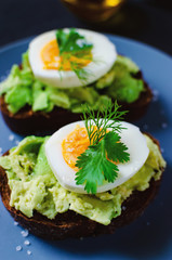 Healthy healthy snack (breakfast) - sandwich with avocado and egg on a gray plate.