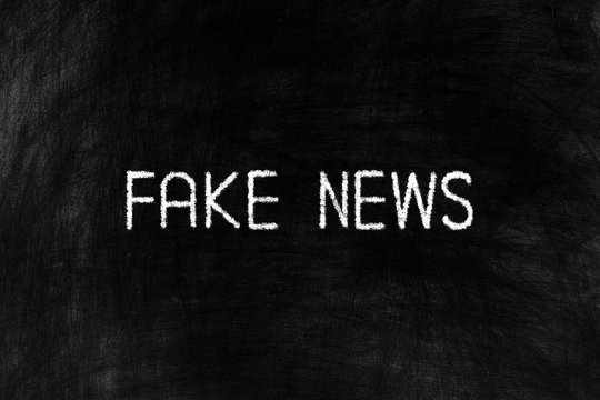 Fake News on Black Chalkboard Background, Suitable for Business Concept.