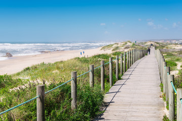 Fototapeta na wymiar Wooden boardwalk at the Praia da Frente Azul, in english the blue beach front in the seaside resort Espinho