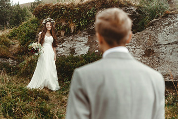 gorgeous bride and stylish groom looking at each other,  boho wedding couple, luxury ceremony at...