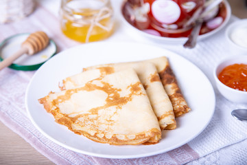 Traditional Russian pancakes with honey, sour cream and jam. Shrovetide. Maslenitsa week. Selective focus, close-up.