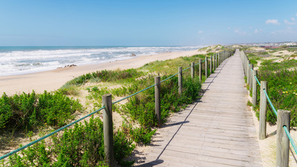 Fototapeta na wymiar Wooden boardwalk at the Praia da Frente Azul, in english the blue beach front in the seaside resort Espinho