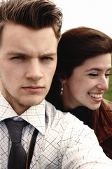 stylish brunette beautiful woman and man in love having funny selfies in windy spring field