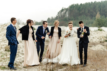 bride and groom with happy groomsmen and bridesmaids having fun and popping champagne, luxury wedding celebration, hilarious moment