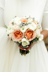 beautiful elegant bride holding and looking at luxury natural wedding bouquet