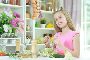 Obraz na płótnie Canvas Portrait of cute girl preparing delicious fresh salad