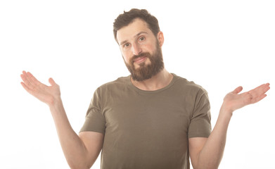 I don't know. Young bearded man isolated on white background being at a loss, showing helpless gesture with arm and hands. 