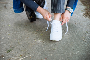 woman tie shoelaces on sneakers